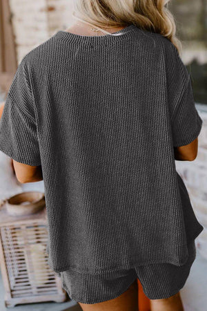 a woman wearing a grey top and shorts