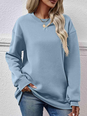 a woman wearing a blue sweatshirt and jeans