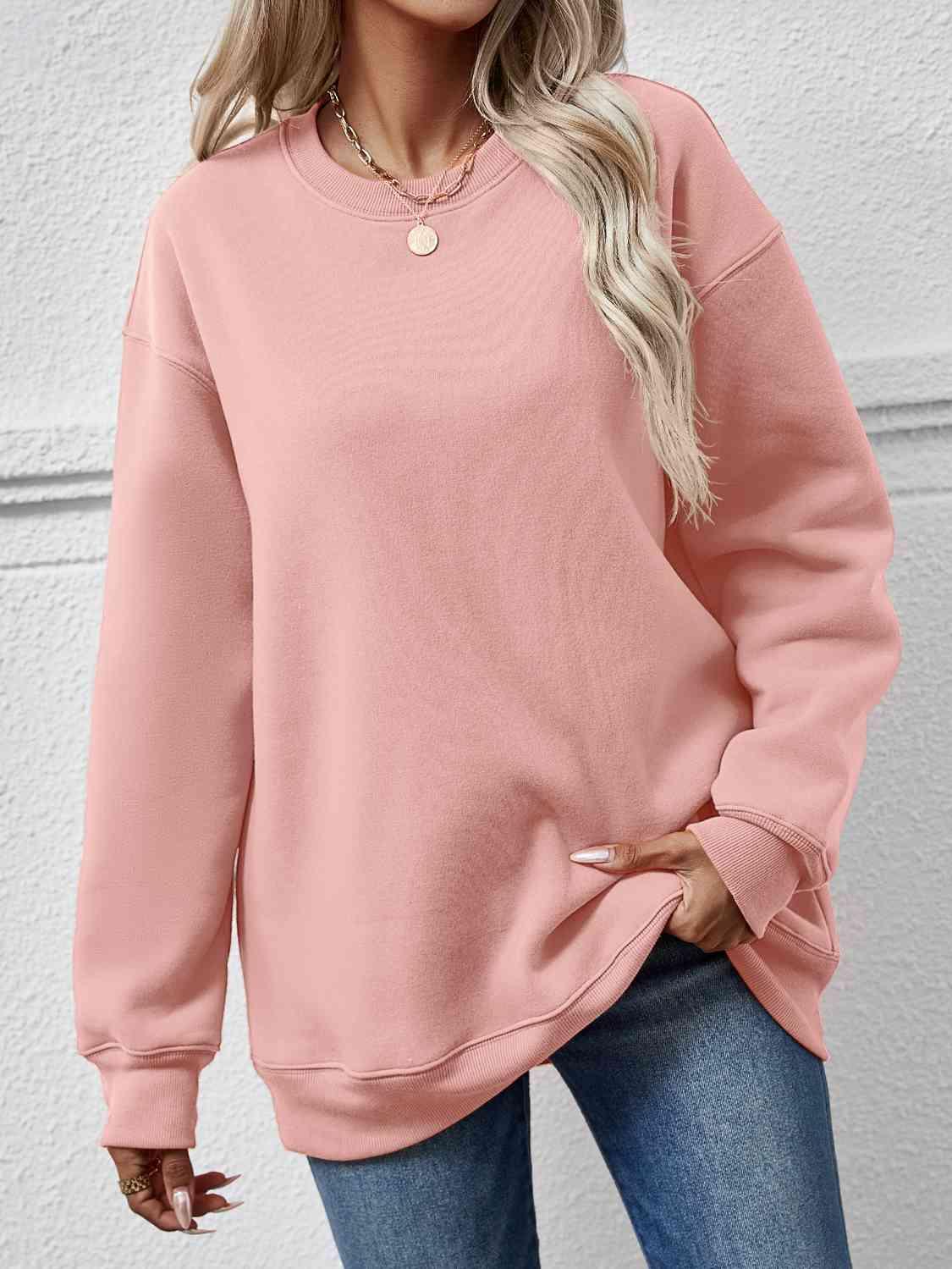 a woman wearing a pink sweatshirt and jeans