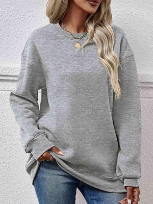 a woman wearing a grey sweatshirt and jeans
