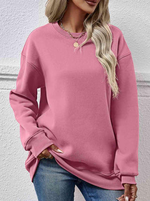 a woman wearing a pink sweatshirt and jeans