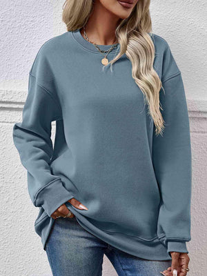 a woman wearing a blue sweatshirt and jeans