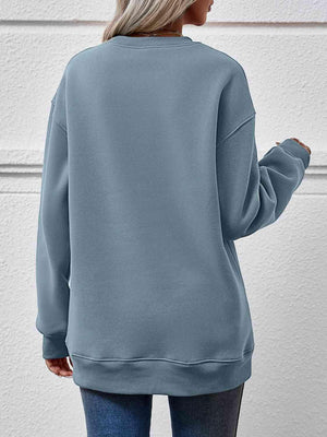 a woman wearing a blue sweatshirt and jeans