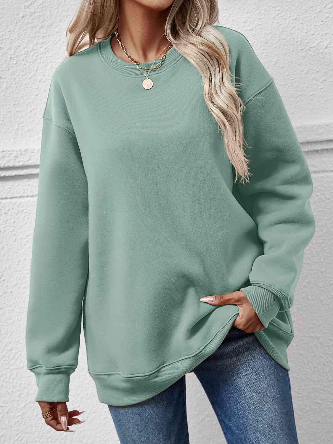 a woman wearing a green sweatshirt and jeans