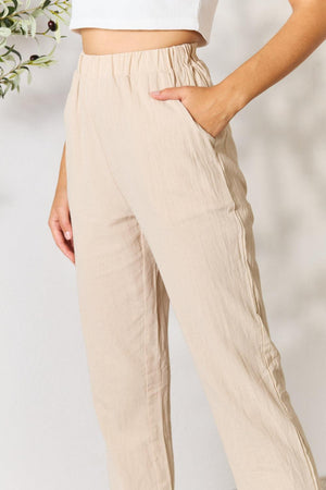 a woman in a white top and tan pants
