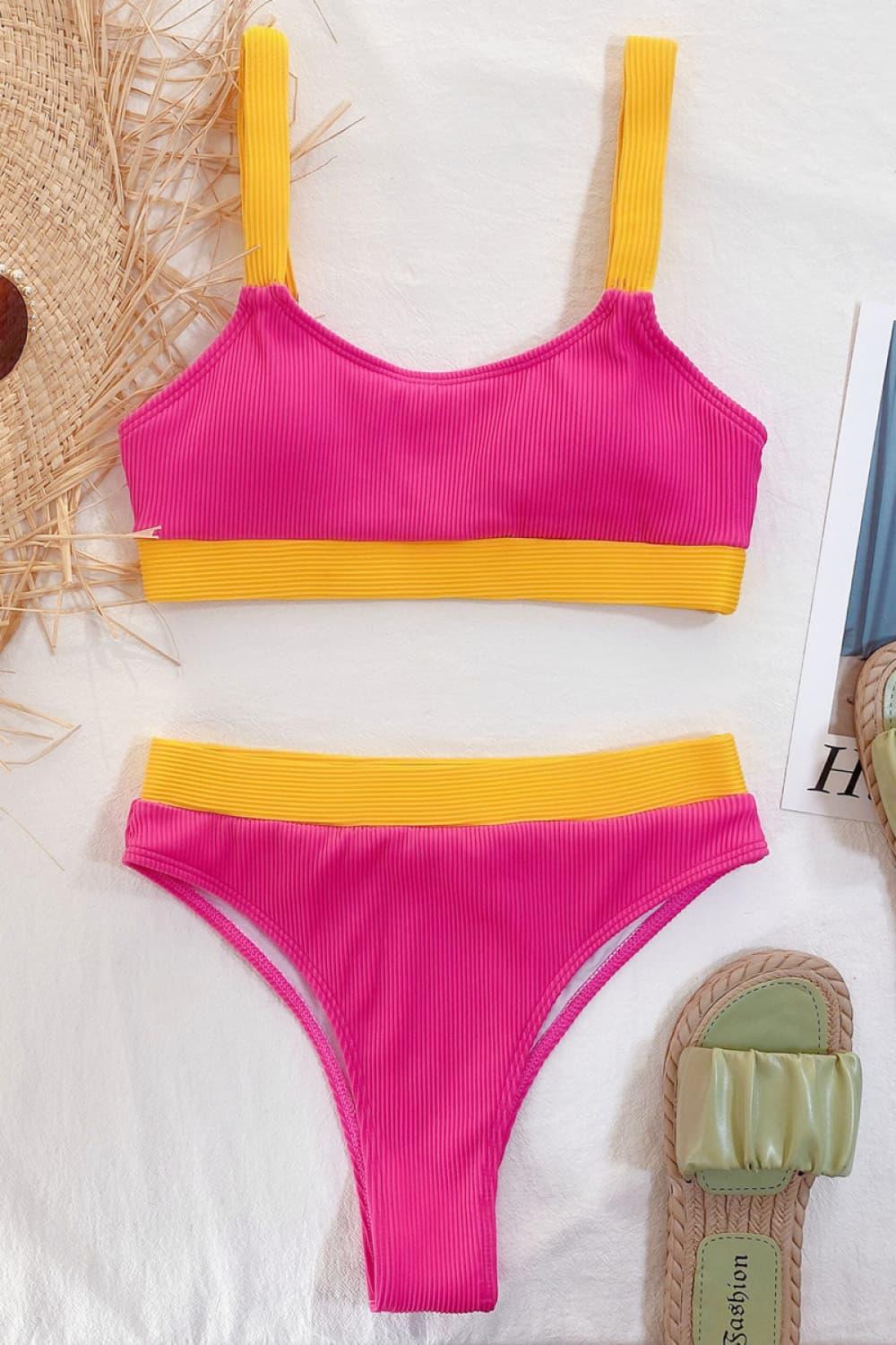 a pink and yellow swimsuit next to a straw hat