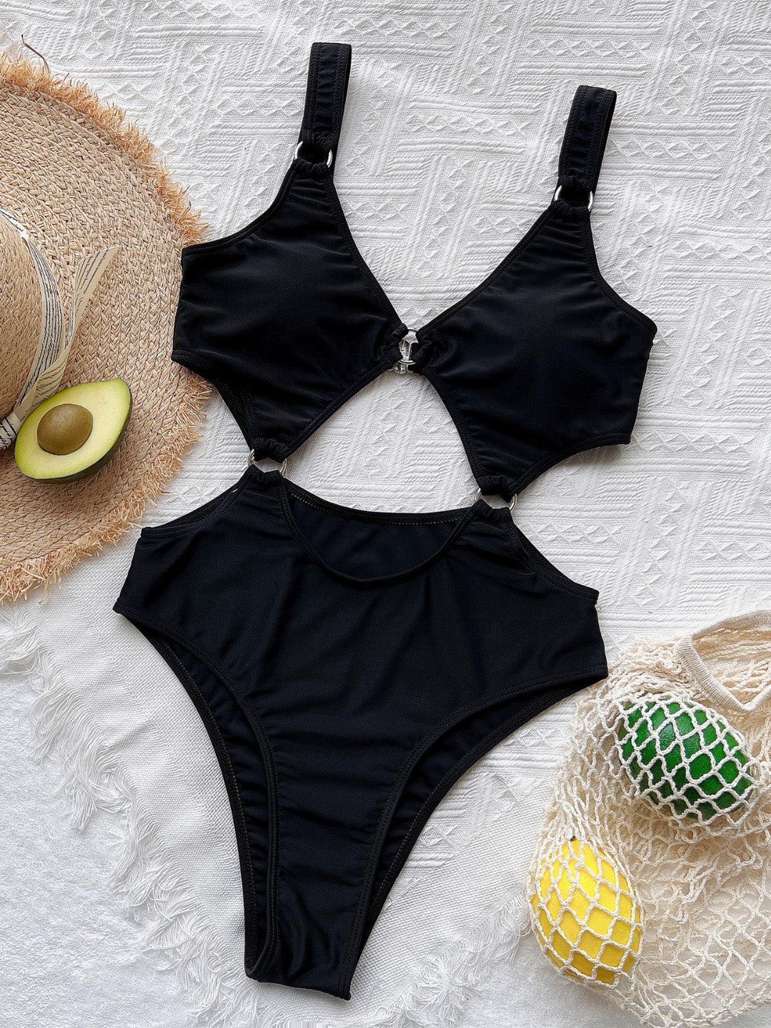 a woman's black swimsuit and hat on a bed
