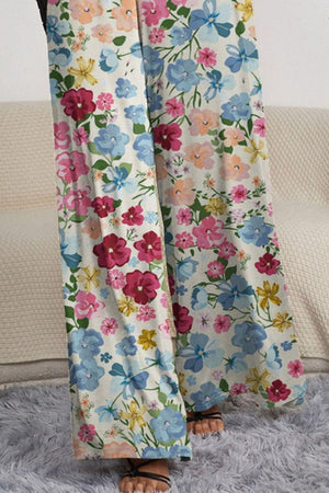 a woman standing on a rug wearing floral pants