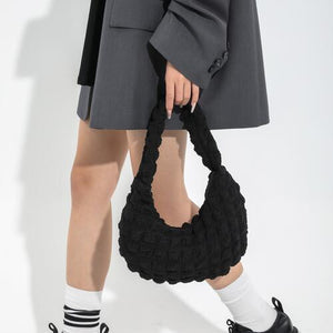 a woman is holding a black crochet bag