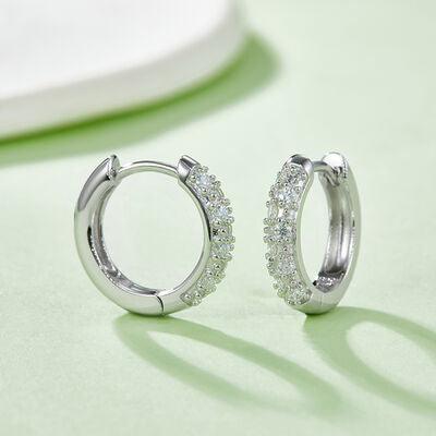 a pair of diamond hoop earrings on a green surface