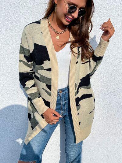 a woman wearing a camouflage cardigan sweater and jeans