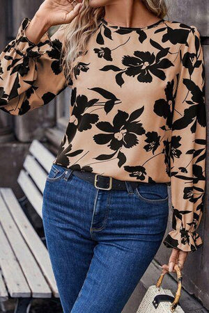a woman wearing a floral blouse and jeans
