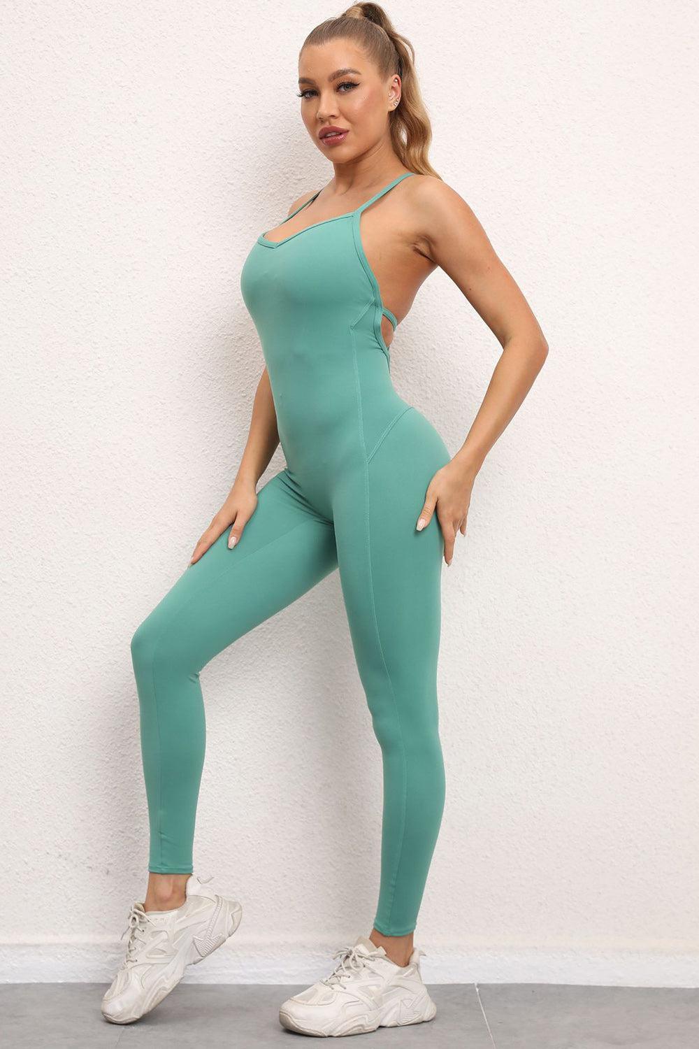 a woman in a green bodysuit posing for a picture