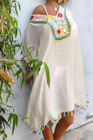 a woman wearing a white ponchy with colorful beads