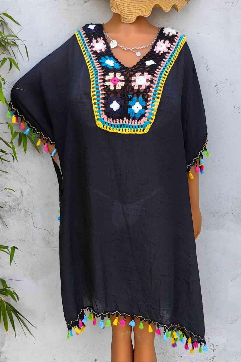 a mannequin wearing a black top with colorful pom poms