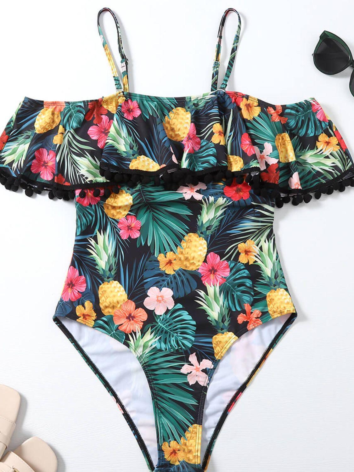 a swimsuit with pineapples and flowers on it