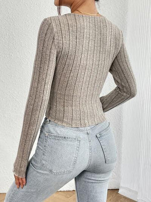a woman in jeans and a sweater posing for the camera