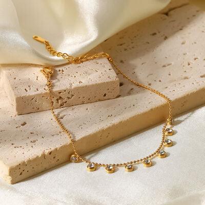 a gold chain bracelet on a white cloth