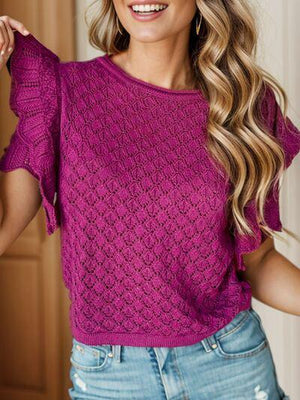 a woman wearing a purple top and jeans