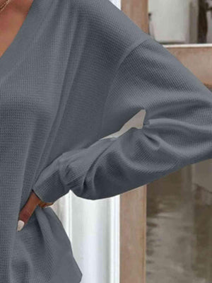 a woman wearing a gray sweater and jeans