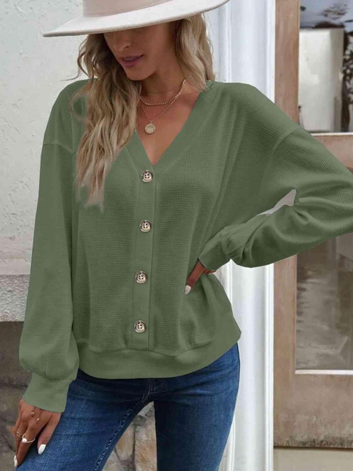 a woman wearing a green blouse and jeans