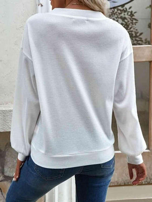 a woman wearing a white sweater and jeans