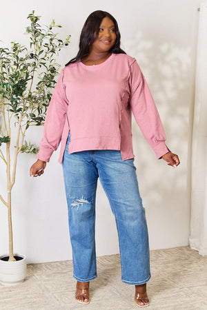 a woman standing in front of a potted plant