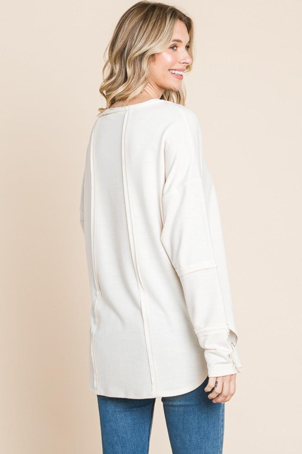 a woman wearing a white sweater and jeans
