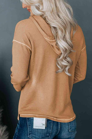 a woman wearing a tan sweater and jeans