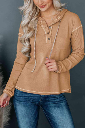 a woman wearing a tan sweater and jeans