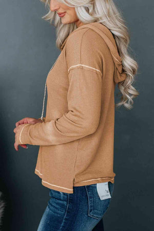 a woman wearing a tan sweater and jeans