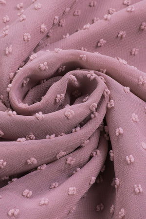 a close up of a pink fabric with small white flowers