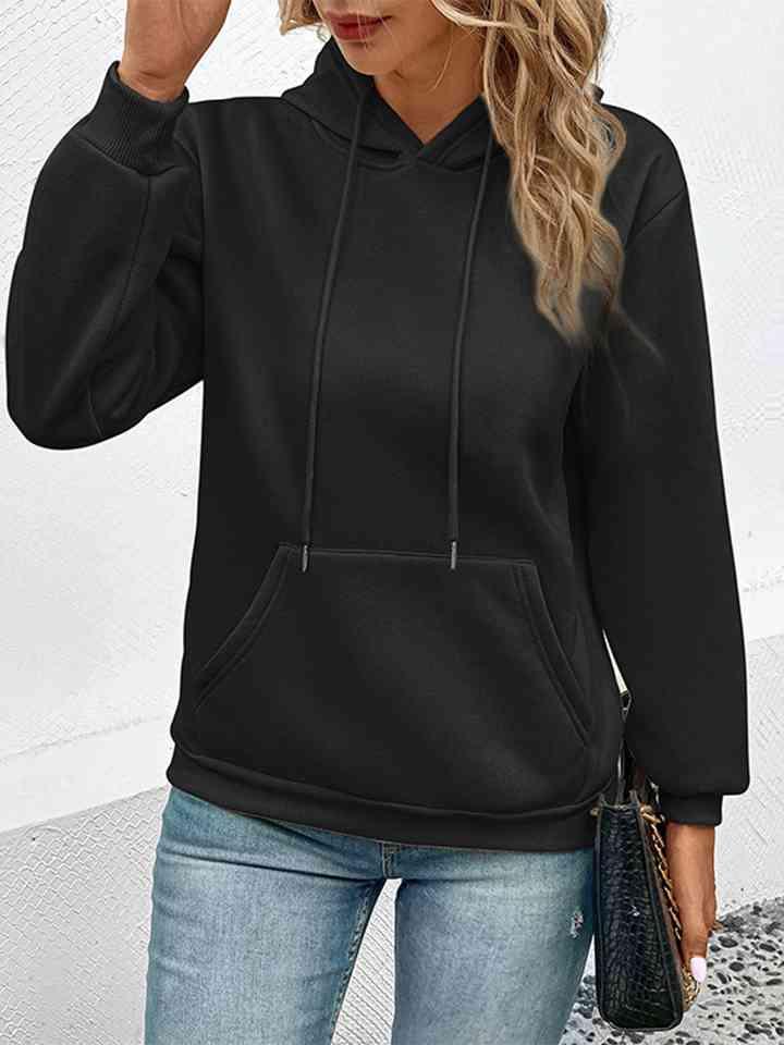 a woman wearing a black hoodie and jeans