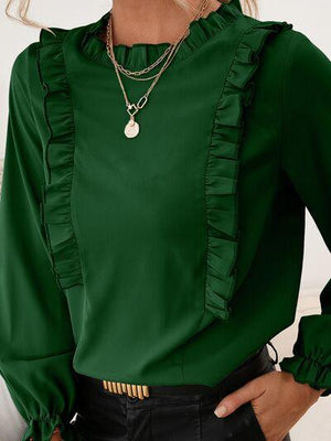 a woman wearing a green blouse and black pants