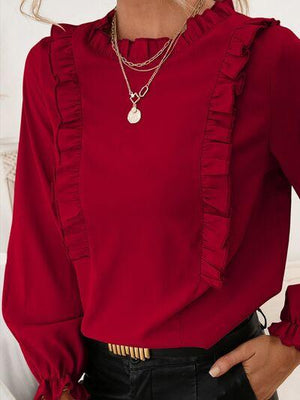 a woman wearing a red blouse and black pants