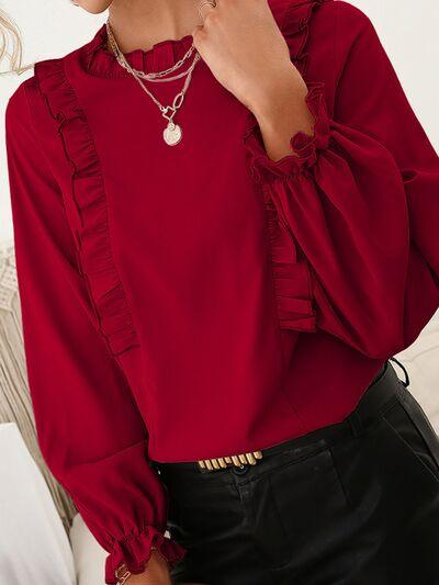a woman wearing a red blouse and black pants