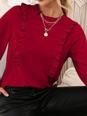 a woman wearing a red top and black pants