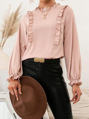 a woman wearing a pink blouse and black pants