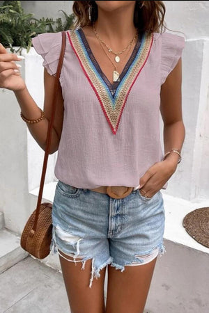 a woman wearing a pink top and denim shorts