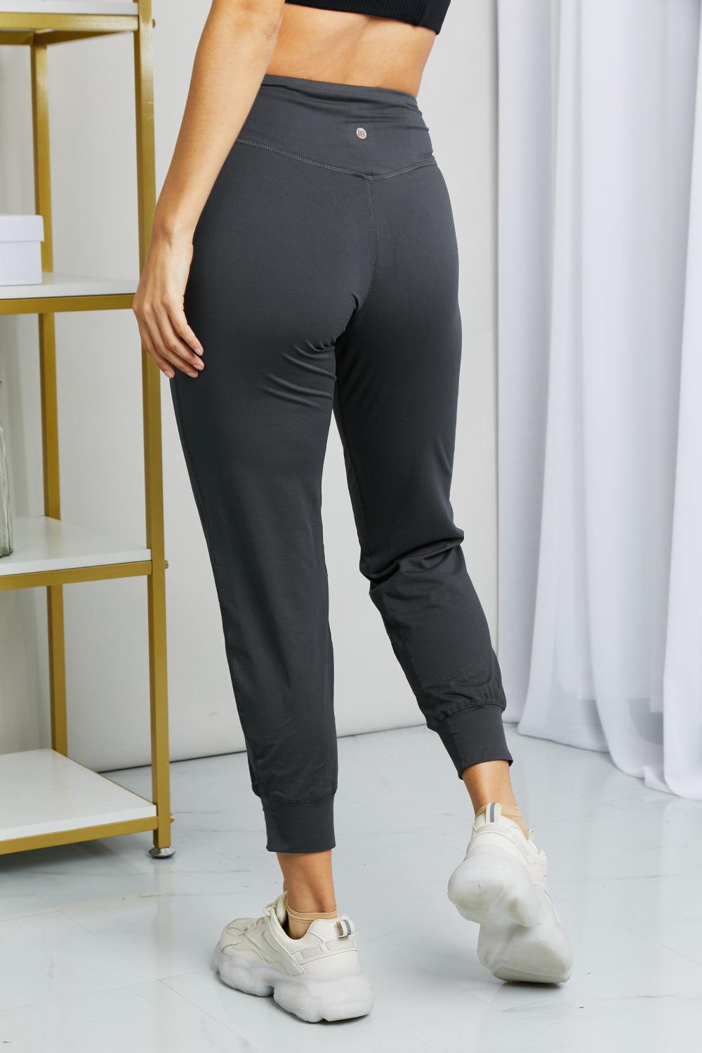 a woman in a black top and grey pants