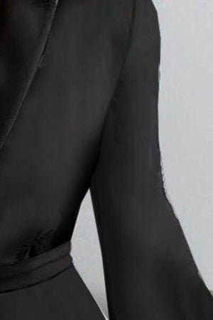 a woman wearing a black dress and a black tie