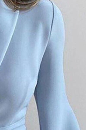 a woman in a light blue dress with her hands on her hips