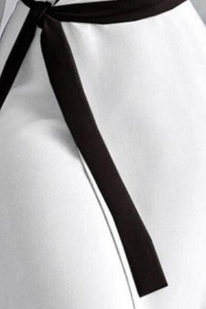 a woman wearing a white shirt with a black tie around her waist