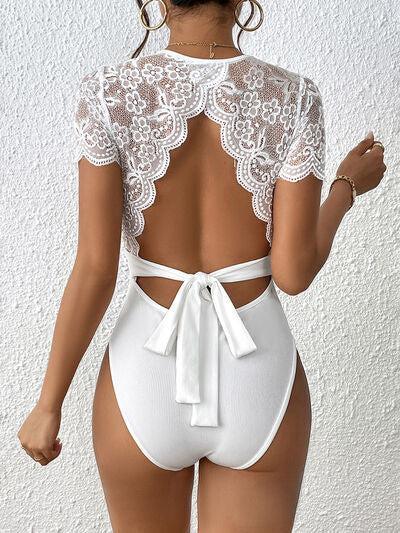 a woman wearing a white lace backless swimsuit