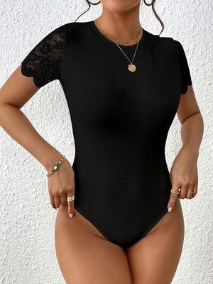 a woman in a black bodysuit posing for the camera