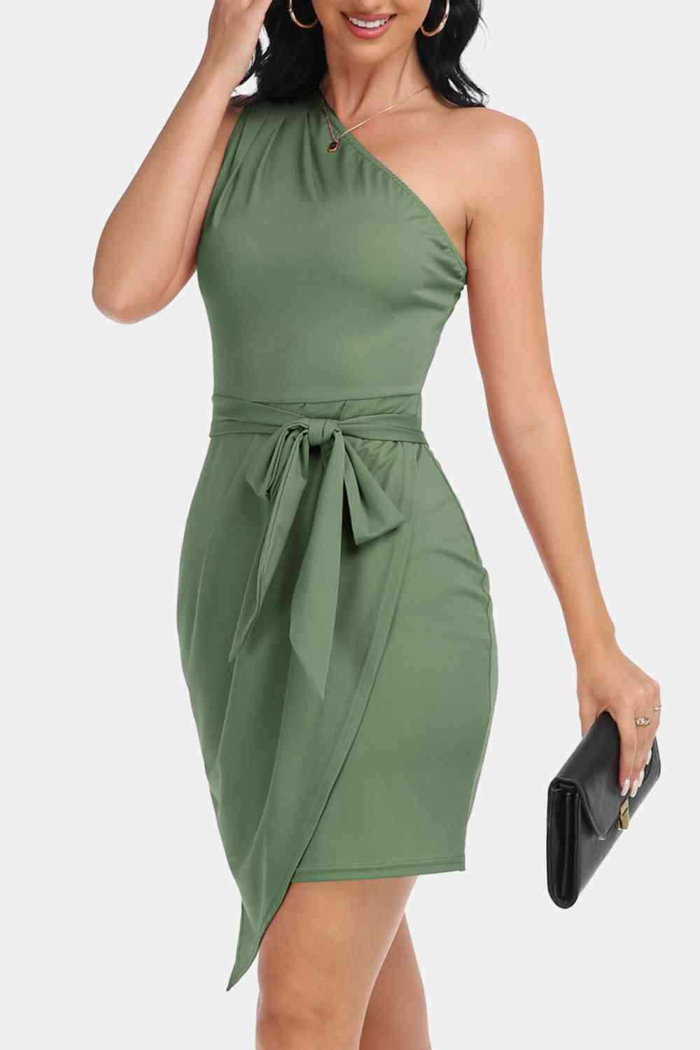 a woman wearing a green dress and holding a black purse