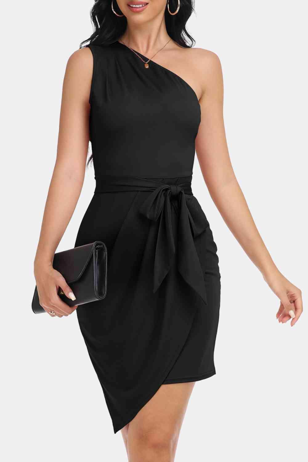 a woman in a black dress with a clutch