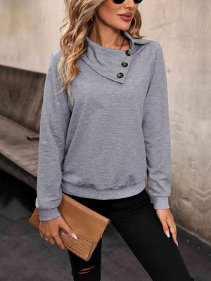 a woman wearing a grey sweater and black pants