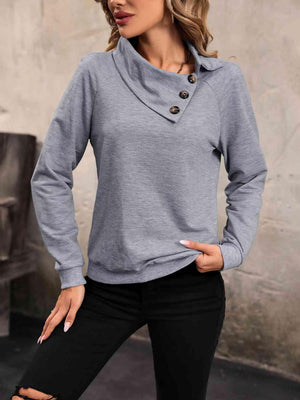 a woman wearing a grey sweater and black pants