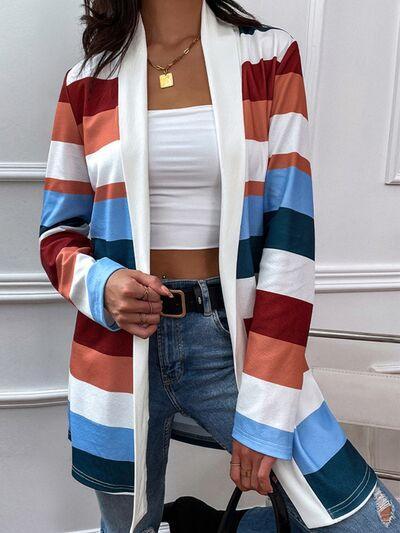 a woman wearing a striped cardigan and jeans